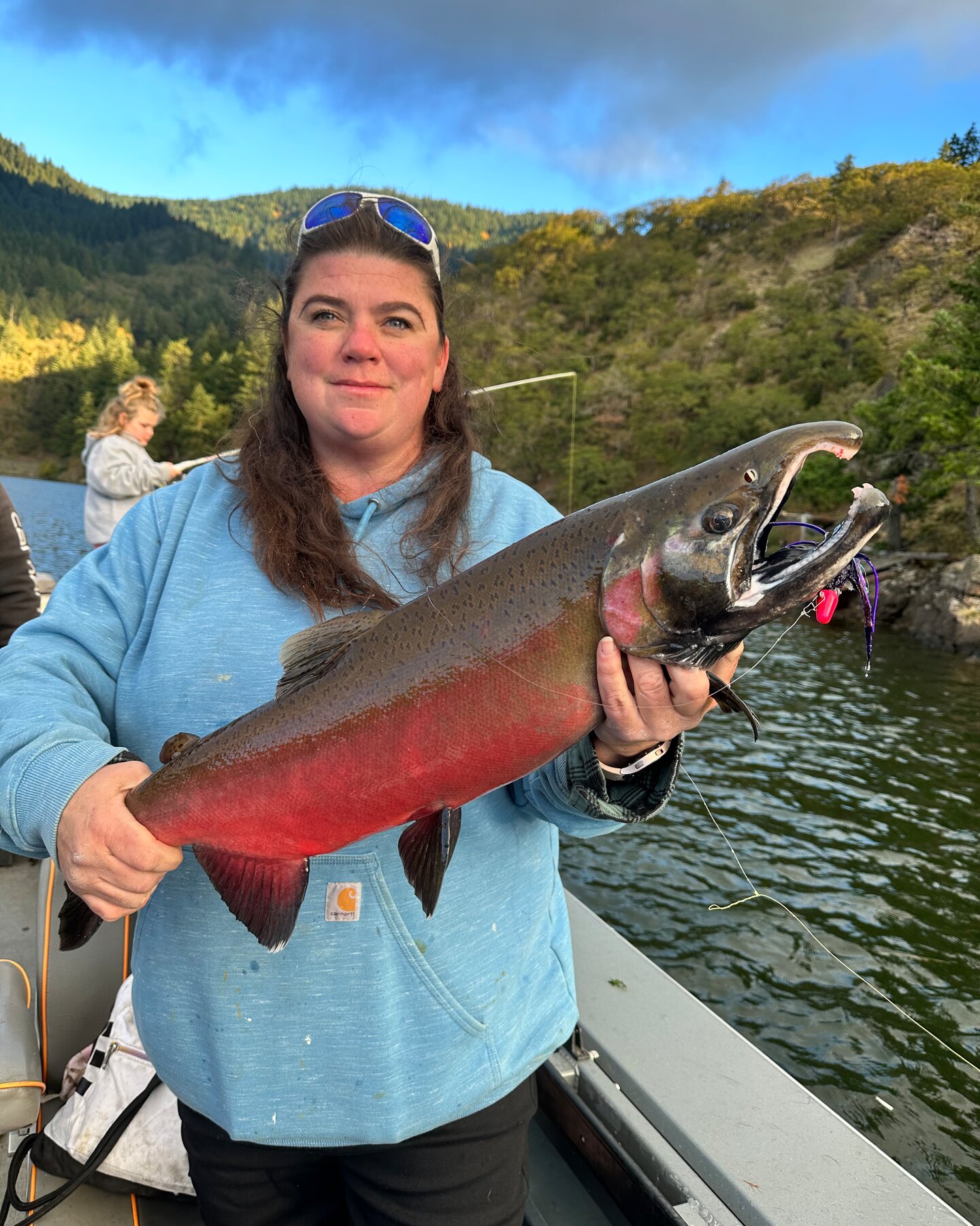 Angler holding a colored-up coho salmon on the river