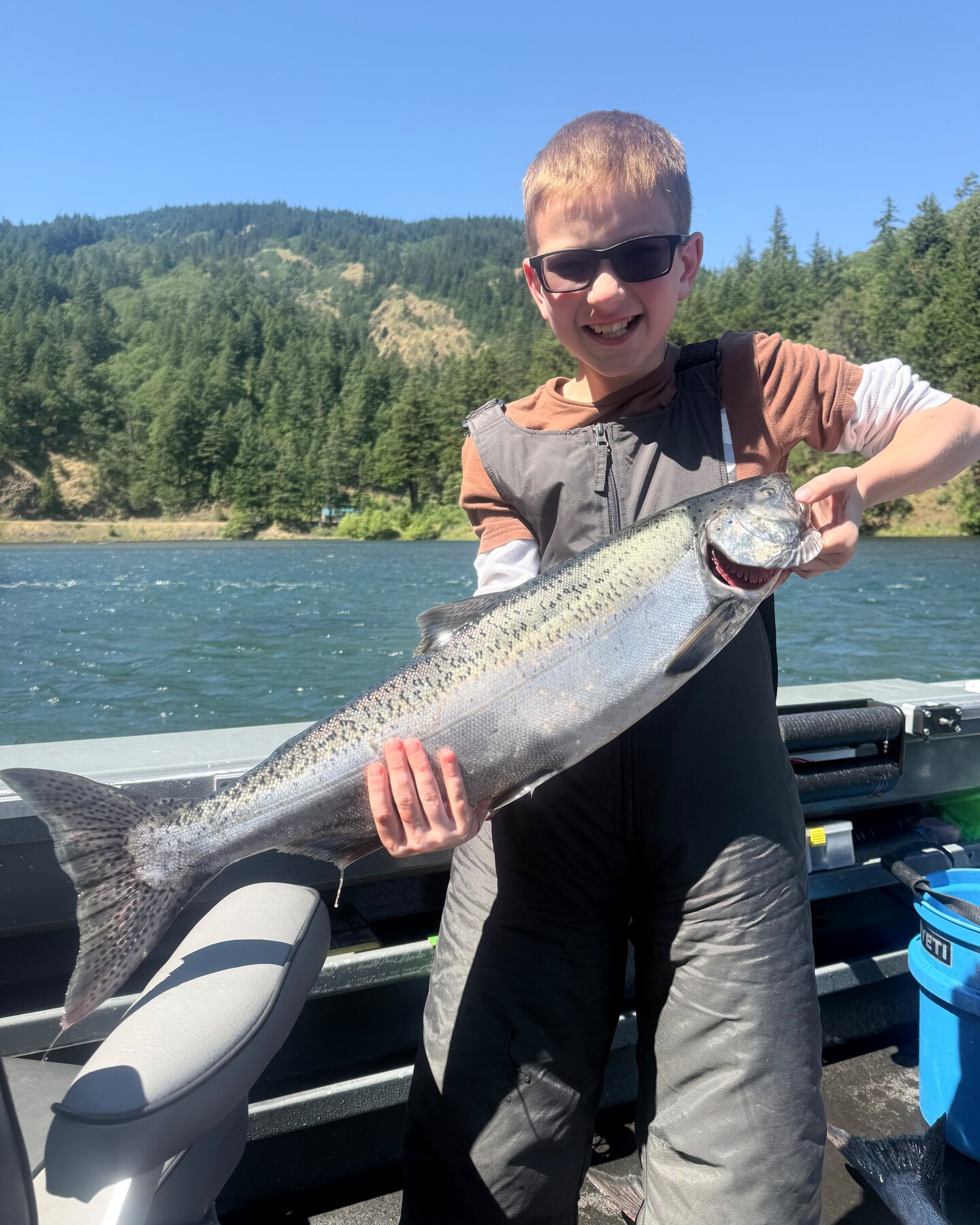 Young angler holding up his spring chinook salmon on a guided trip